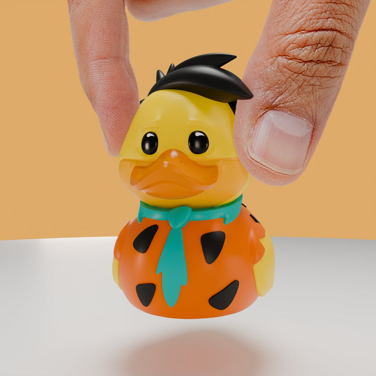 The Flintstones Fred Flintstone TUBBZ Mini Edition collectible duck, held between finger and thumb to show its size